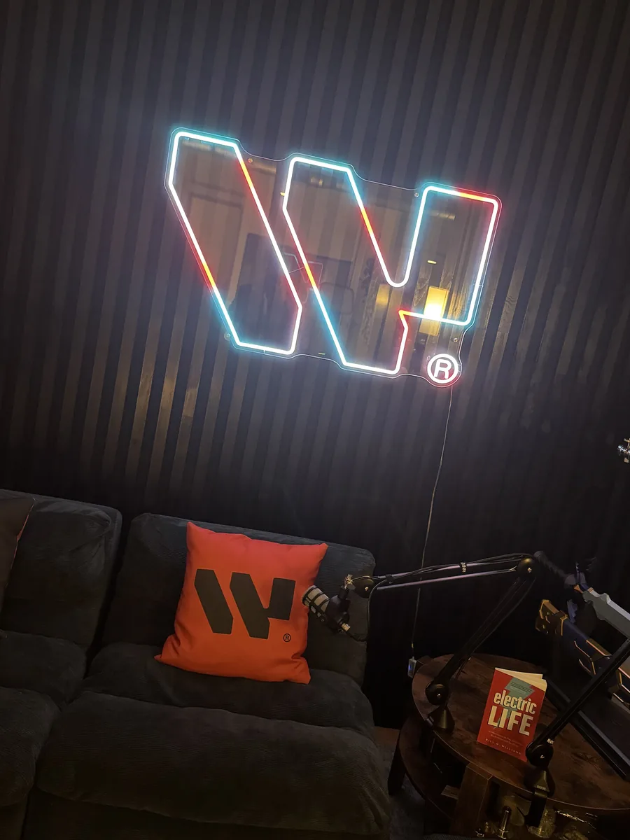 The Webisoft neon logo on the studio wall